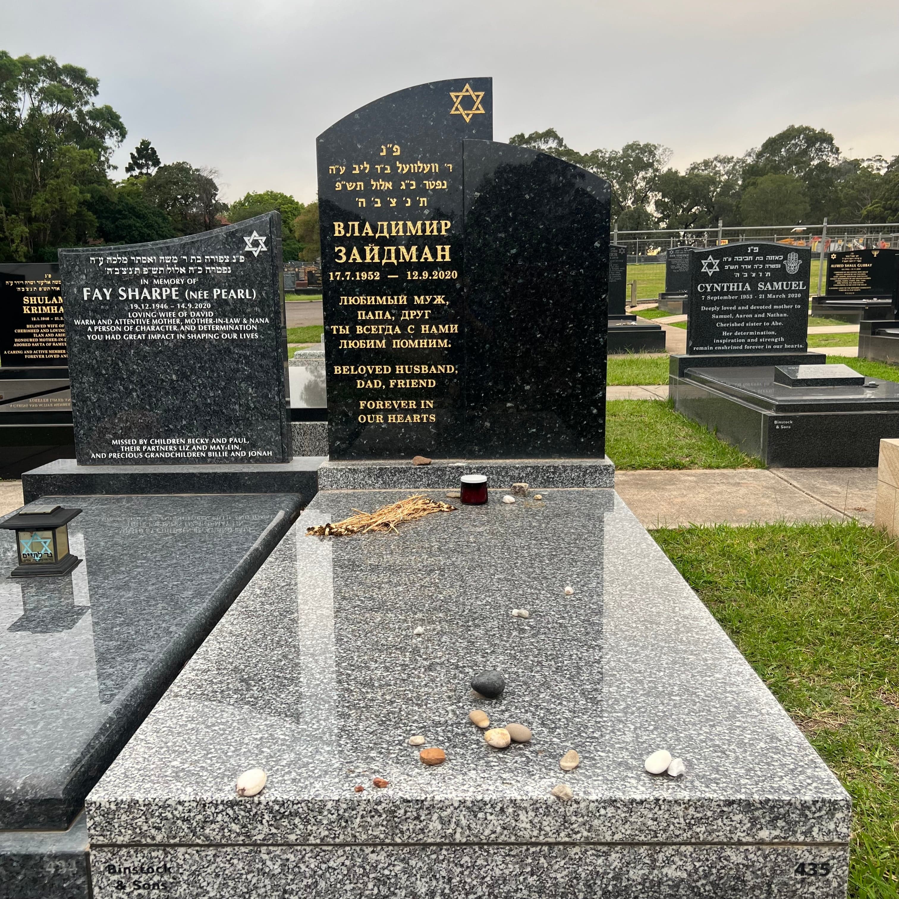 Double full Jewish monument with a custom shaped headstone, gold leaf lettering, and riverena and emerald pearl granite.