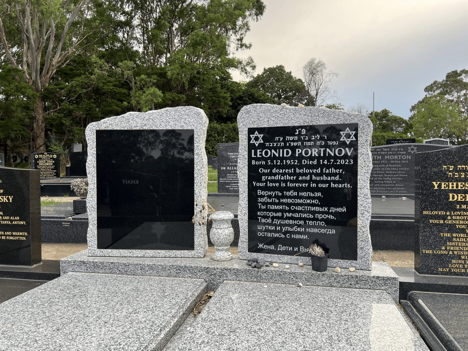 Double full Jewish monument with a rock edged shaped headstone, white paint lettering, and harcourt and jet black granite.