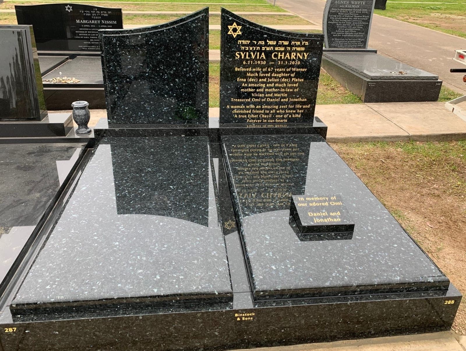 Double full Jewish gravestone with two arch shaped headstones, gold leaf lettering, and emerald pearl granite.
