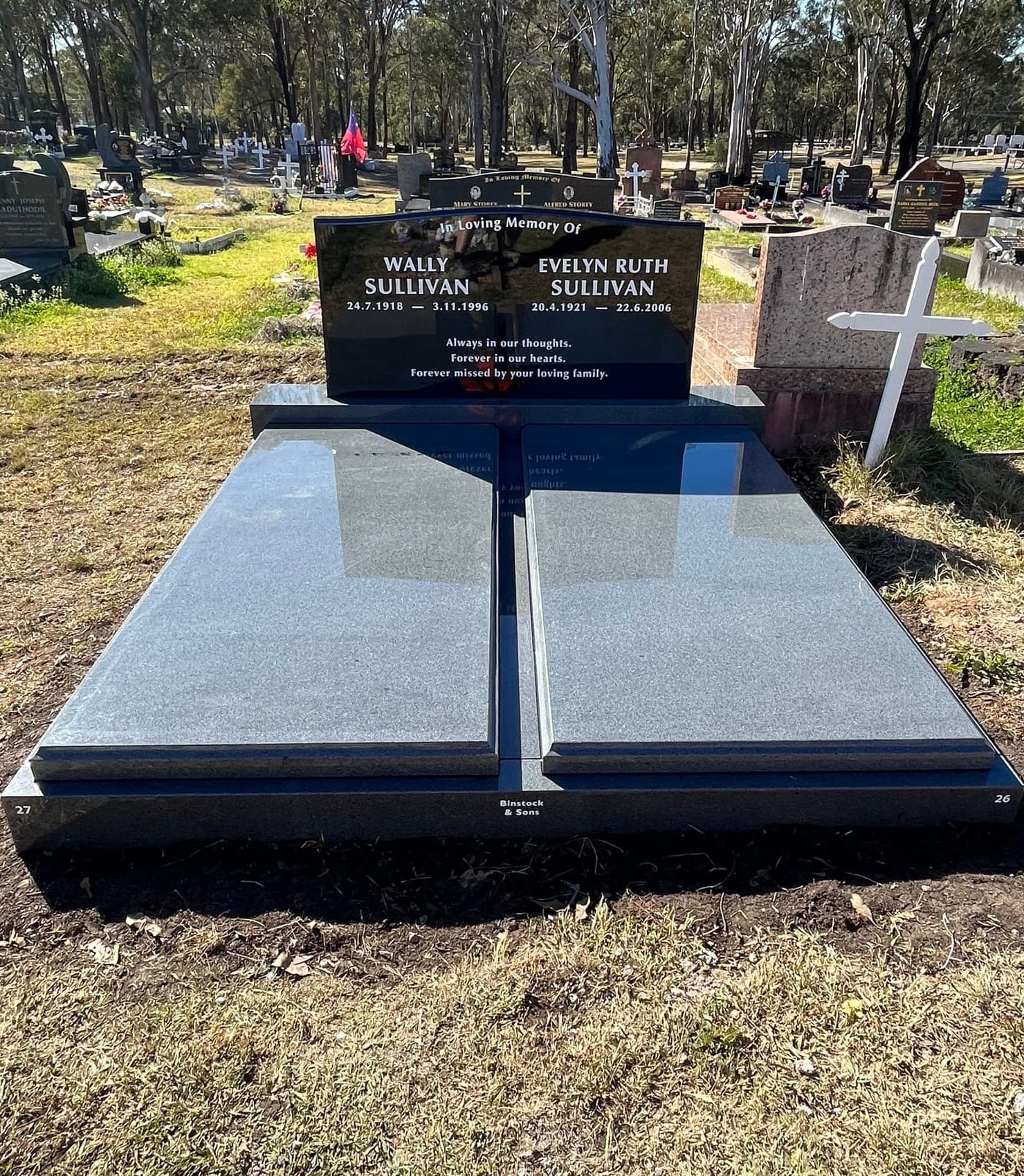 Double full gravestone with a serpentine-shaped headstone, white paint lettering, and jet black granite.