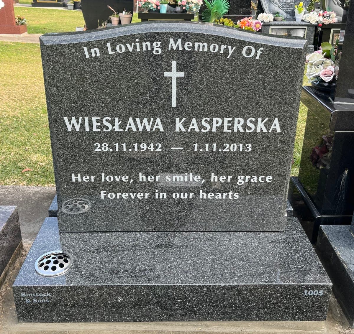 Single memorial with a serpentine-shaped headstone, base, natural cut-in lettering, and noble grey granite.