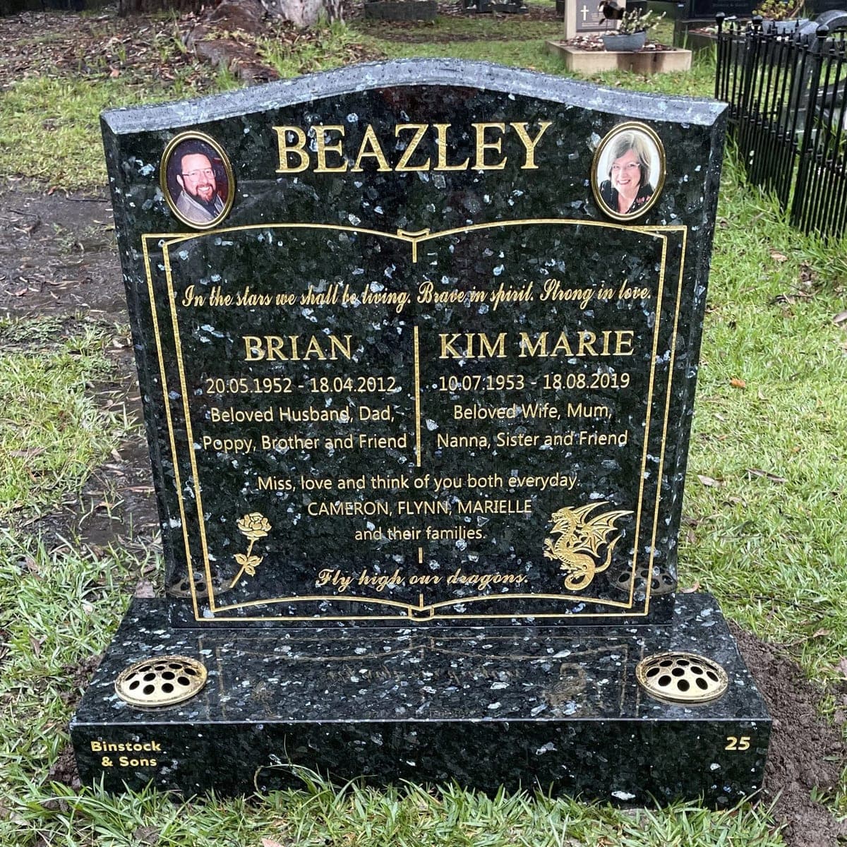 Double monument with a serpentine-shaped headstone, base, gold leaf lettering, and emerald pearl granite.