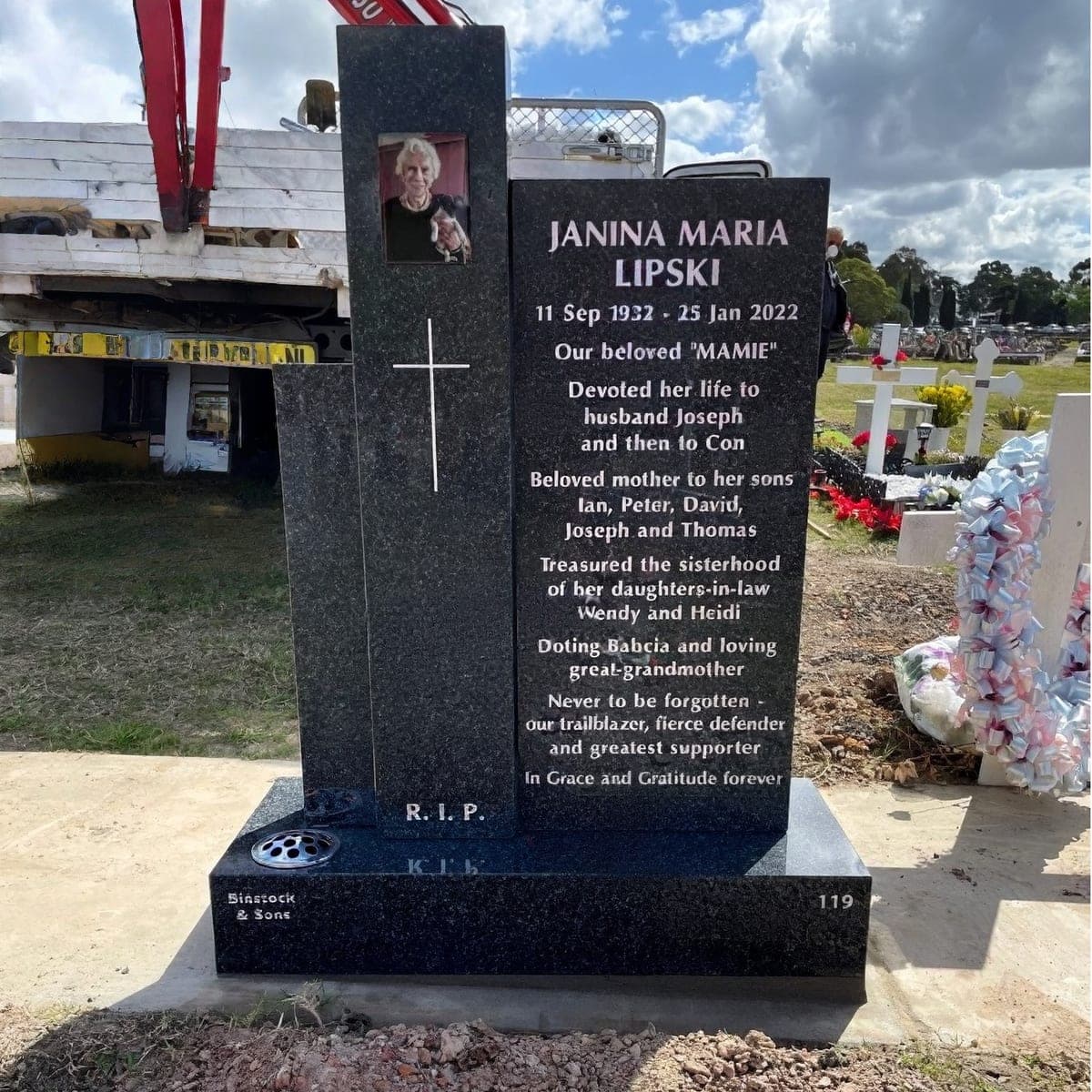 Single monument with a "three pillars" headstone, base, white paint lettering, and galaxy black granite.