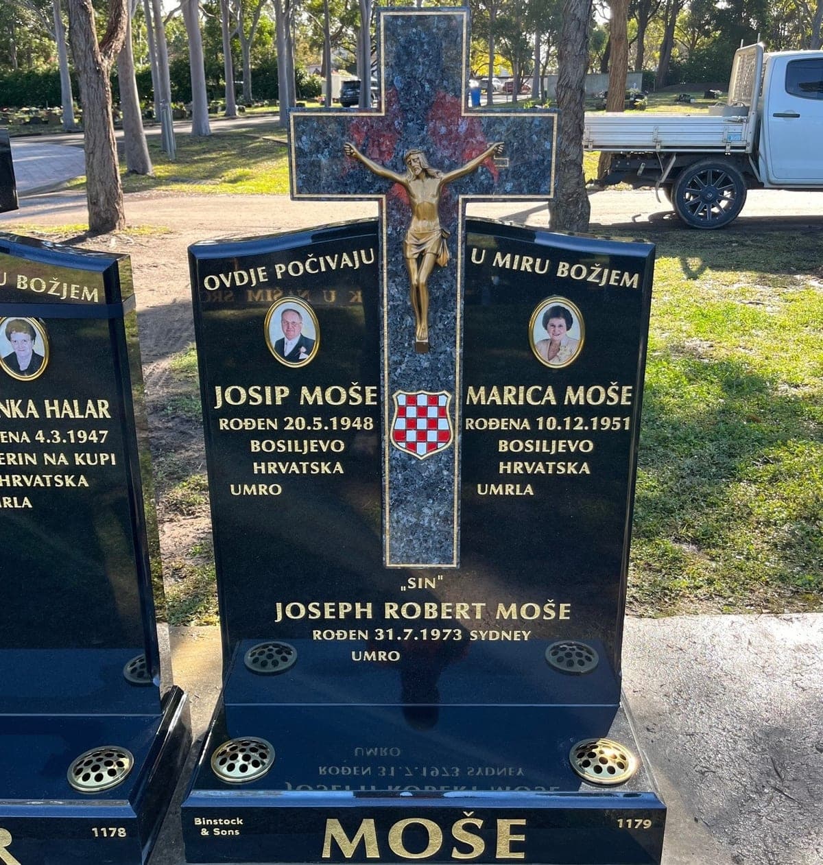 Croatian double monument with a serpentine-shaped & cross headstone, base, gold leaf lettering, and jet black granite.