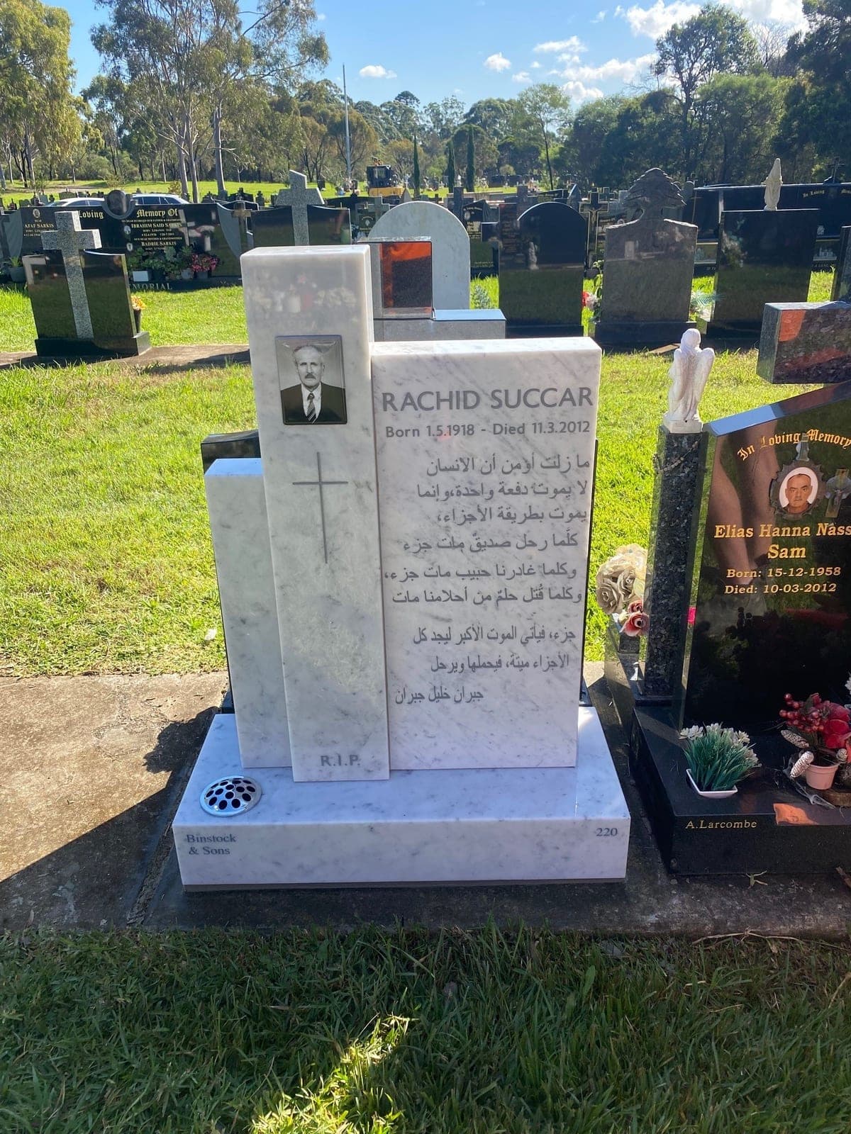 Single monument with a "three pillars" headstone, base, grey paint lettering, and carrara marble.