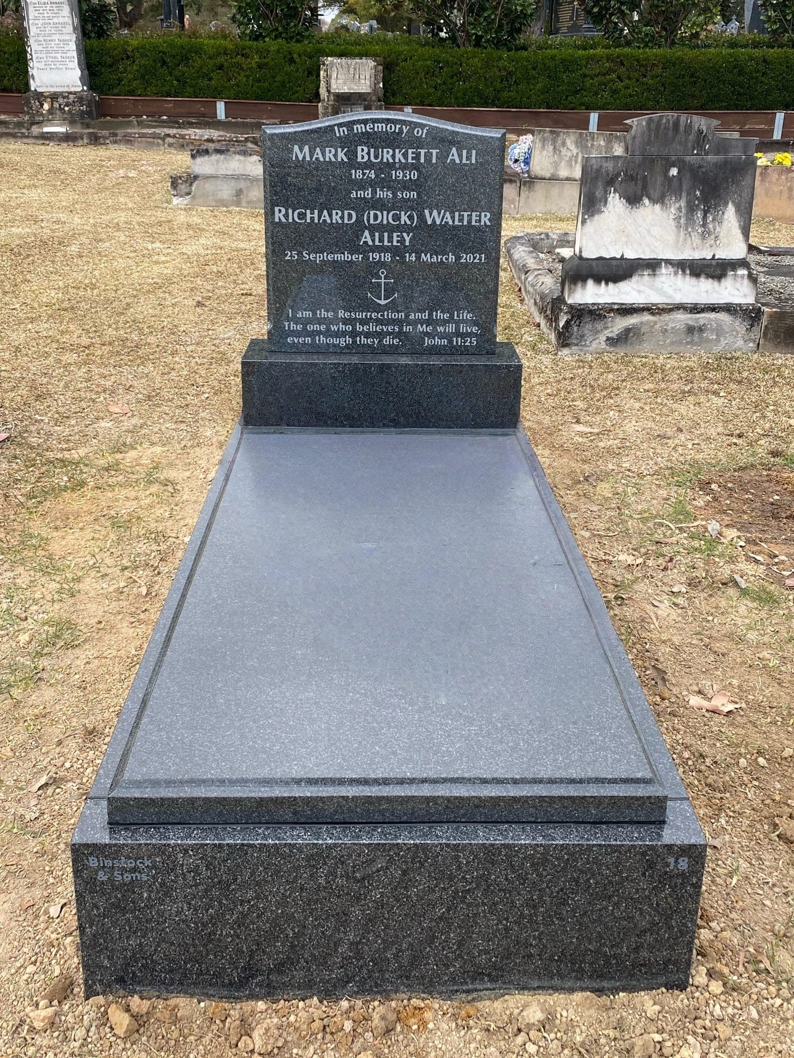 Single full gravestone with a serpentine-shaped headstone, natural cut-in lettering, and noble grey granite.