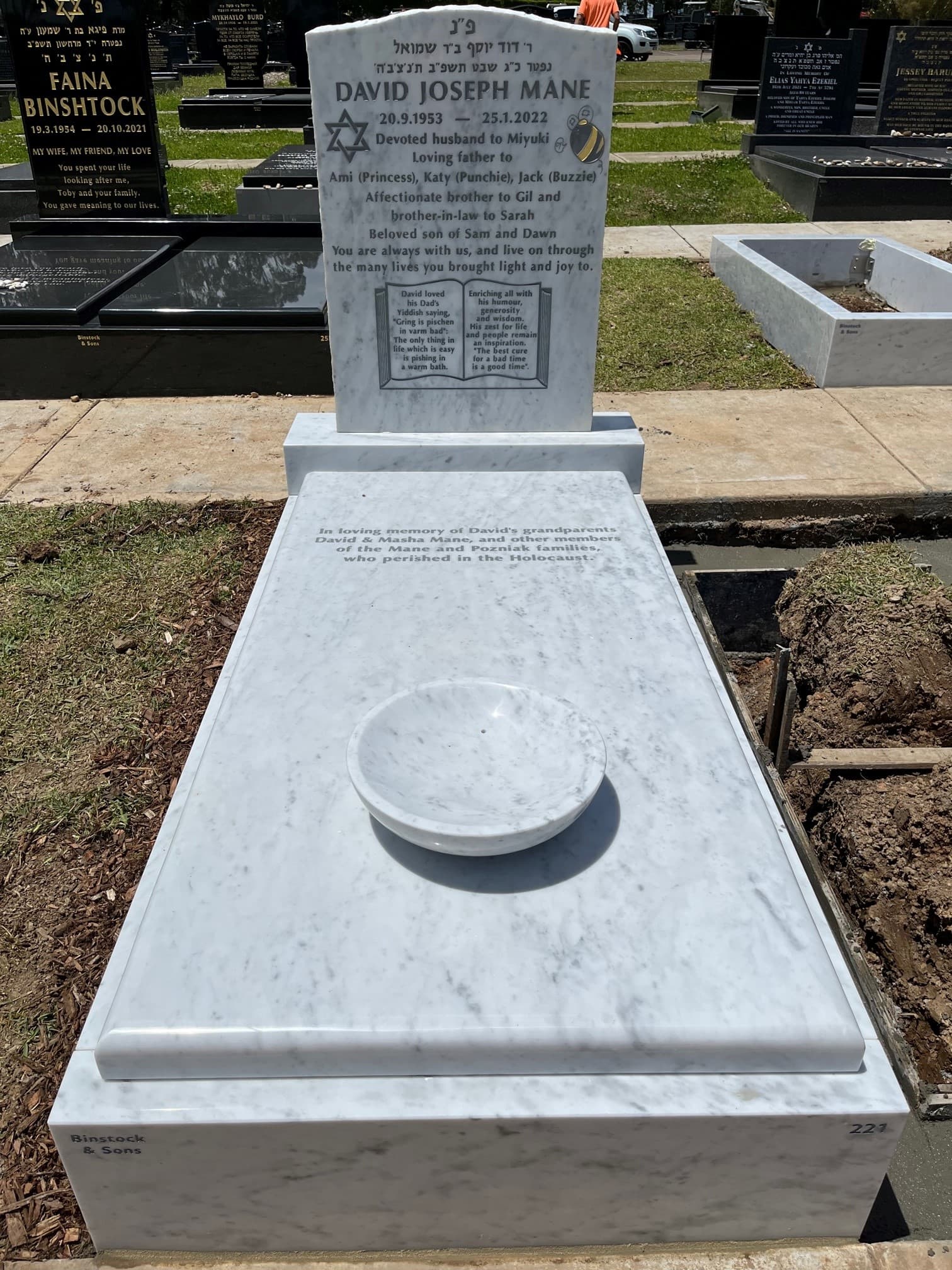 Single full Jewish gravestone with a serpentine-shaped headstone, black paint lettering, and carrara marble.