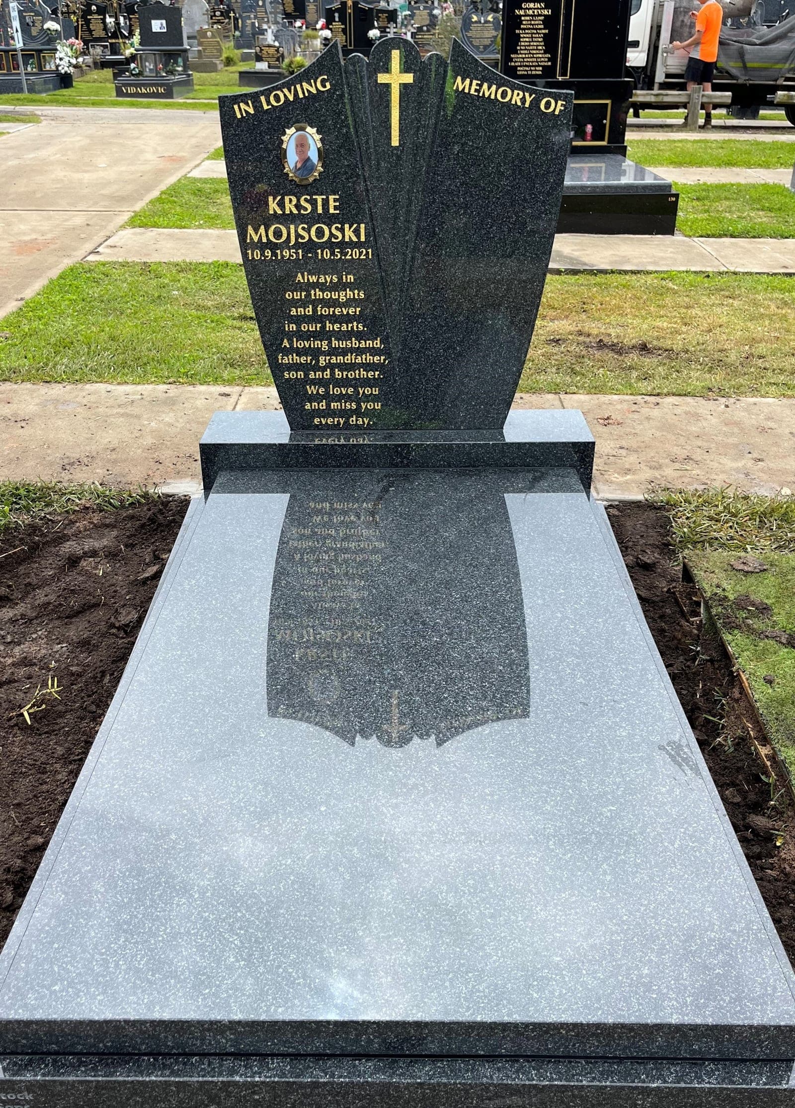 Single full Macedonian gravestone with a fan-shaped headstone, gold leaf lettering, and noble grey granite.
